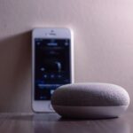 Smartphone met Google Home app naast een smart speaker tijdens het instellen van een apparaat