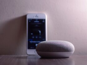 Smartphone met Google Home app naast een smart speaker tijdens het instellen van een apparaat